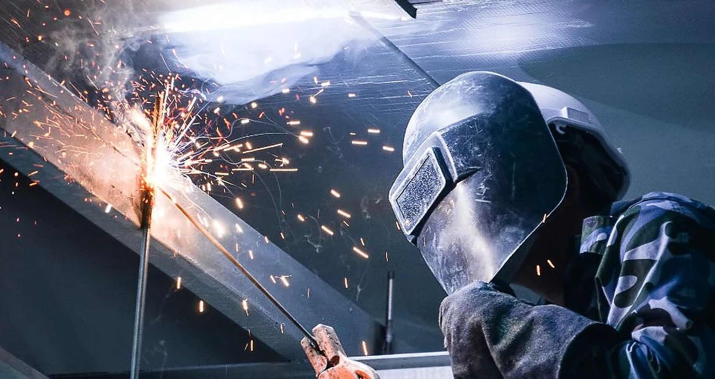 Soldadura industrial en curso, chispas sobre estructura metálica