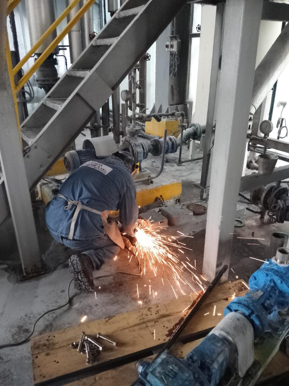 Técnicos en plataforma elevada realizando montaje de línea de producción